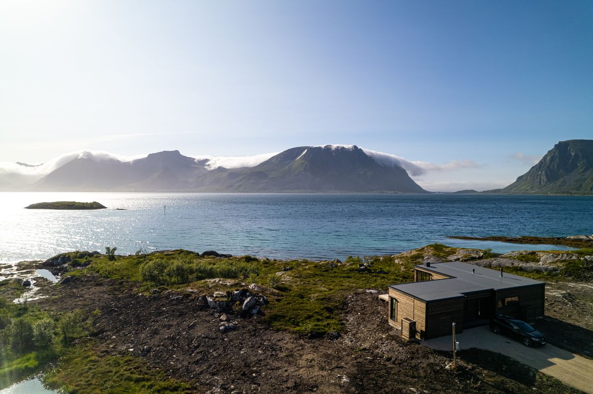 The coast at Lyngvær with meadow, water and mountains