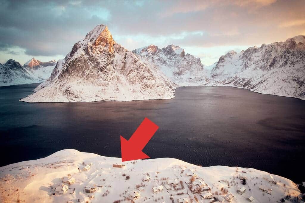 Aerial view of Reinefjord in winter, an arrow marks where the house stands above the water