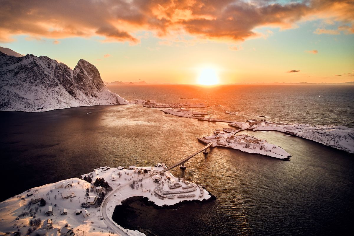 Low sun over the sea near Reine, snowy islands in the foreground